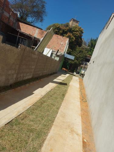 a sidewalk next to a wall next to a building at Pousada Tropical in Aparecida