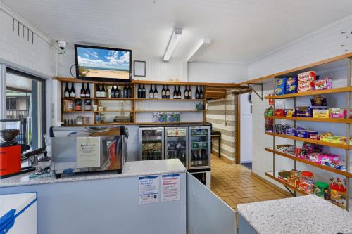 a grocery store with a counter and a tv on the wall at Anchor Belle Holiday Park in Cowes