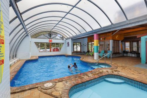 a pool with two people in the water at Anchor Belle Holiday Park in Cowes