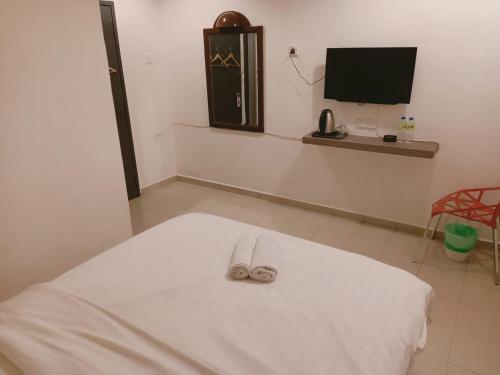 a pair of shoes sitting on top of a bed at T Hotel Anggerik in Alor Setar