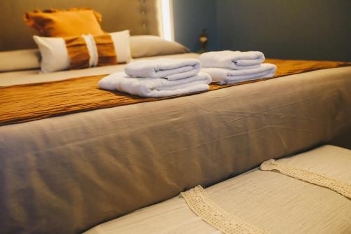 a pile of towels sitting on top of a bed at LG Golden Suites in San Miguel de Tucumán