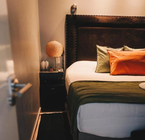 a bedroom with a bed with an orange pillow at LG Golden Suites in San Miguel de Tucumán