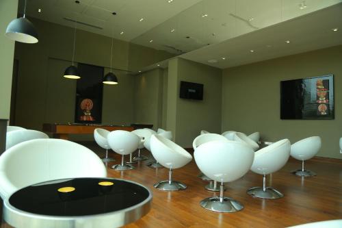 a room with white chairs and a table at Keys Select by Lemon Tree Hotels, Kochi in Cochin