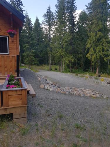 a gravel road next to a log cabin with a house at Golden Spot in Clearwater