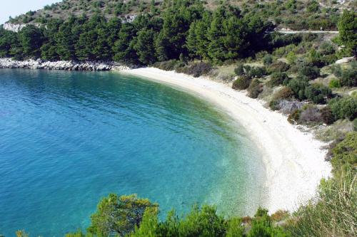 a beach with a white sand and blue water at Apartments by the sea Drvenik Donja vala, Makarska - 9654 in Drvenik