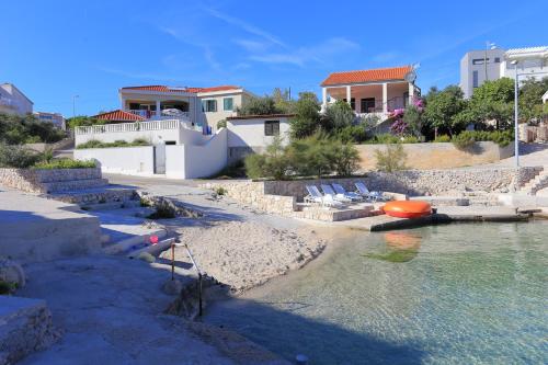 a beach with a house and a boat in the water at Apartment Ostricka luka 11451b in Zaglavice