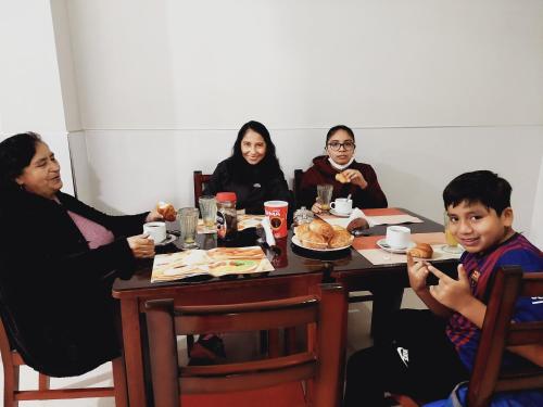 un grupo de personas sentadas alrededor de una mesa comiendo comida en Hotel Real Bolivar, en Chimbote