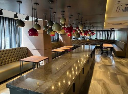 a restaurant with a long counter with tables and chairs at QS Marista - Studio Alessandra Antonelli - flat 1701 in Goiânia
