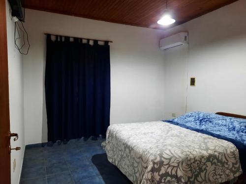 um quarto com uma cama e uma cortina azul em del PARANA em Corrientes