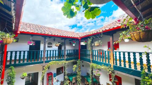 einen Balkon eines Hauses mit Blumenkörben darauf in der Unterkunft Hotel San Gabriel in El Cocuy