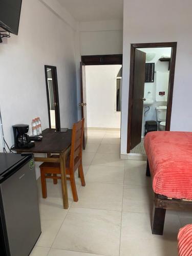 ein Wohnzimmer mit einem Tisch und ein Schlafzimmer in der Unterkunft Casa Lolita in Xilitla