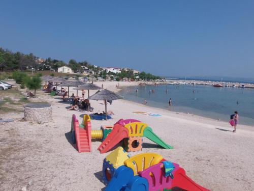 a beach with a bunch of play equipment on it at Family friendly apartments with a swimming pool Vir - Lozice, Vir - 13569 in Vir