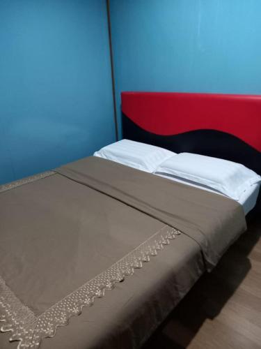 a bed with white pillows and a red and blue wall at Ren-Hana Kundasang in Kundasang