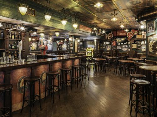 a bar with stools and tables in a pub at H10 Salou Princess in Salou