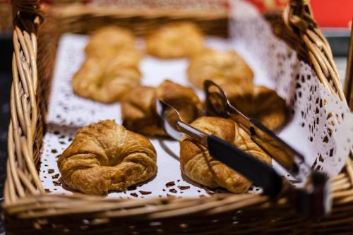 イルフォードにあるベスト ウエスタン ロンドン イルフォード ホテルのテーブルの上に置かれたペストリーがいっぱい入ったバスケット