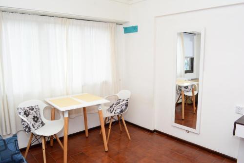 Cette chambre comprend une table, des chaises et un miroir. dans l'établissement Orillas del Nahuel, à San Carlos de Bariloche