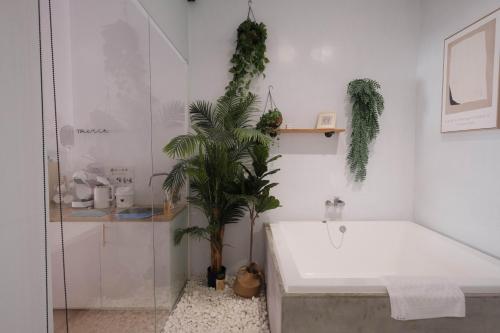 a bathroom with a bath tub and a plant at Privacy Home in Tainan