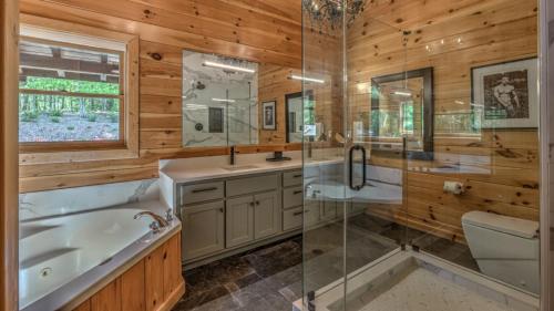 Un baño con bañera, lavabo y ducha. en Endless Echo, en Blue Ridge