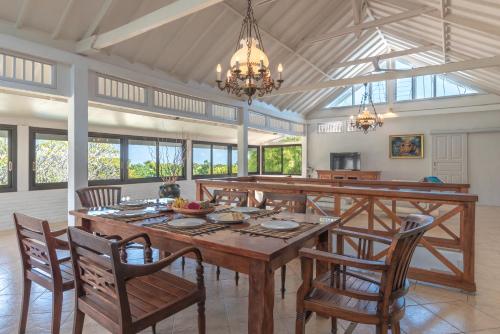 une salle à manger avec une grande table et des chaises en bois dans l'établissement Villa Dinding Batu, à Singaraja