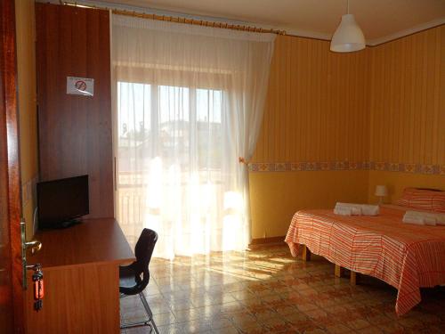 Schlafzimmer mit einem Bett, einem Schreibtisch und einem TV in der Unterkunft B&B A Casa Dei Nonni in Capua
