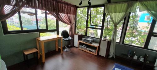 a room with many windows and a desk and a table at Green Homestay in Hanoi