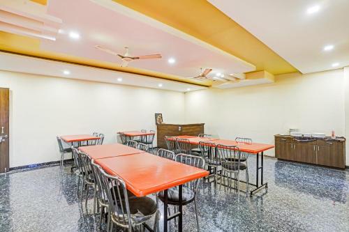 a dining room with orange tables and chairs at Sai Vidisha Palace in Shirdi