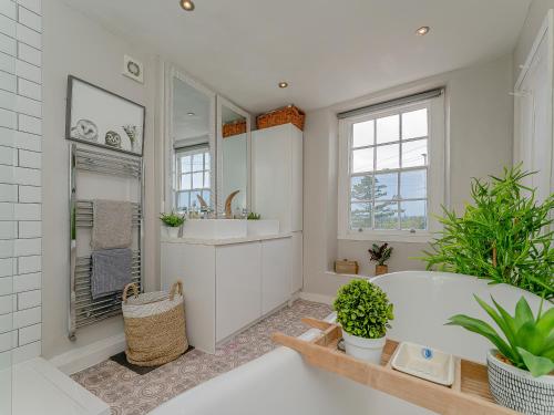 切斯特的住宿－Ivy Cottage，白色的浴室设有浴缸和水槽。
