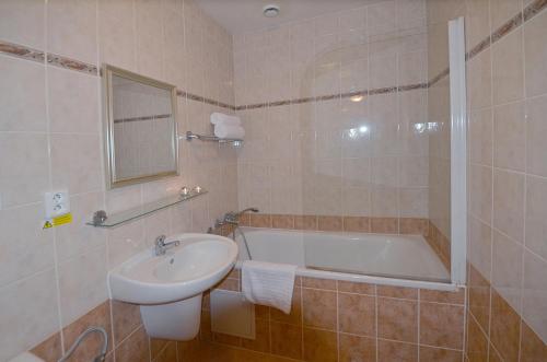 ein Badezimmer mit einem Waschbecken und einer Badewanne in der Unterkunft Apartement Hrebenka in Harrachov