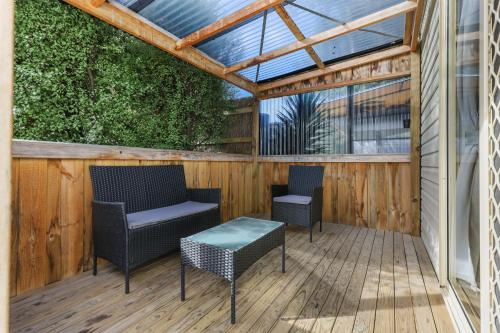 a pergola with two chairs and a table on a wooden deck at Anchor Belle Holiday Park in Cowes