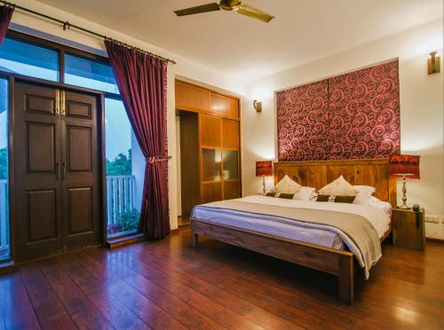 a bedroom with a large bed and a large window at House of Kapaali in Greater Noida