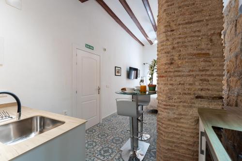 - une cuisine avec un évier et un mur en briques dans l'établissement Tosca 2 PAX by costablancarent, à Dénia