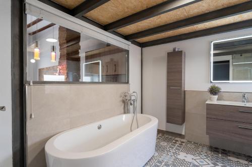 een badkamer met een wit bad en een wastafel bij Suite Loft 4 PAX by costablancarent in Denia