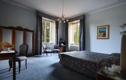 a bedroom with a bed and a table and chairs at Hotel Villa Delle Rose in Pescia