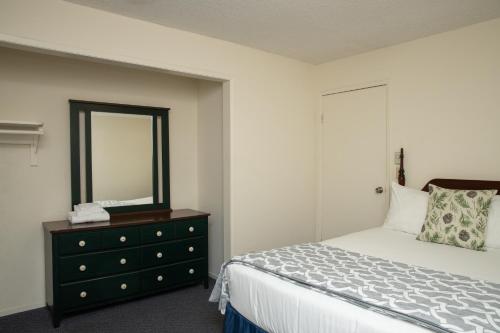 a bedroom with a bed and a dresser with a mirror at The Occidental Lodge in Occidental