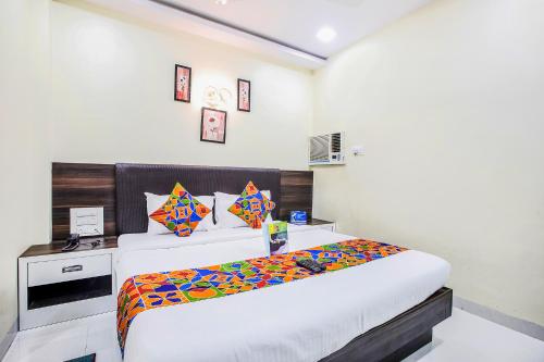 a bedroom with a bed and a desk in it at FabExpress The Grand Kohinoor - Behind APMC in Turambhe