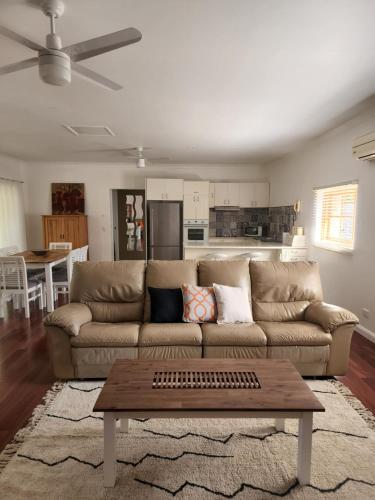 a living room with a couch and a table at Brom Cottage in Mooloolah