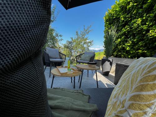 a patio with chairs and a table and a fire place at Mid Mountain Apartment Tirol in Wiesing