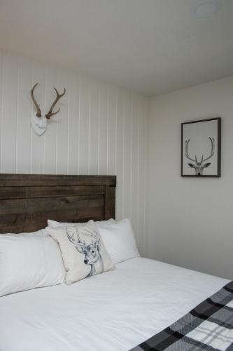 a bedroom with a white bed with antlers on the wall at The Occidental Lodge in Occidental