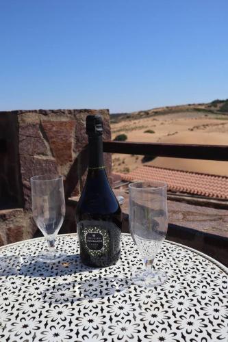 a bottle of wine sitting on a table with two glasses at Le Dune Dorate in Torre Dei Corsari