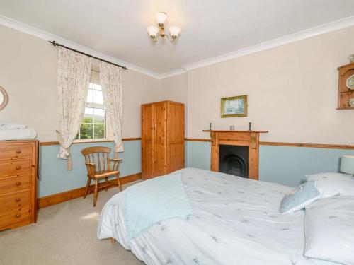 a bedroom with a bed and a fireplace at Tor View Fourwinds in Okehampton