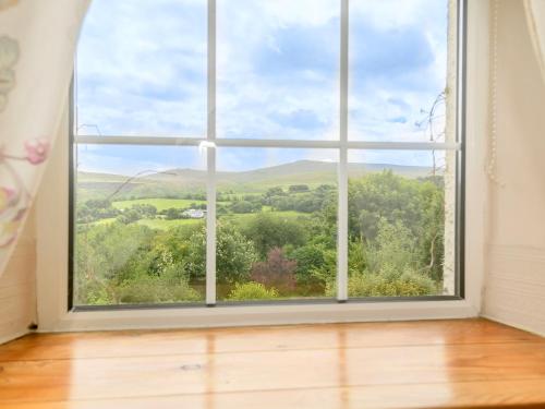a window with a view of the countryside seen through it at Tor View Fourwinds in Okehampton
