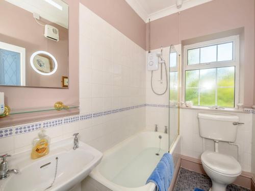 a bathroom with a tub and a toilet and a sink at Tor View Fourwinds in Okehampton