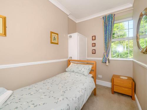 a small bedroom with a bed and a window at Tor View Fourwinds in Okehampton