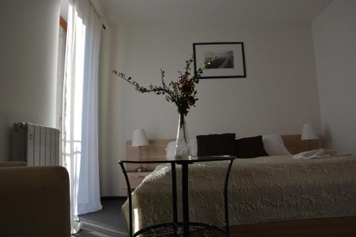 a living room with a table with a vase of flowers on it at Sport Klub Hvozd in Hvozd