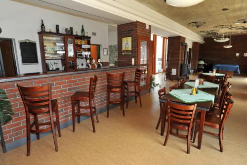 ein Restaurant mit Tischen und Stühlen und einer Ziegelwand in der Unterkunft Sport Klub Hvozd in Hvozd