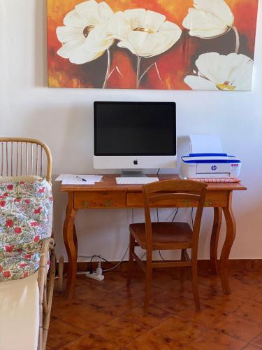 a desk with a computer monitor and a chair at La Casa sulla Spiaggia: Dimora Elma in San Lorenzo