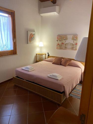 a bedroom with a bed with two towels on it at La Casa sulla Spiaggia: Dimora Elma in San Lorenzo
