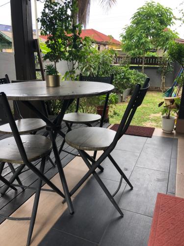 uma mesa e cadeiras num pátio com uma mesa em Rose Guest House em Kota Bharu