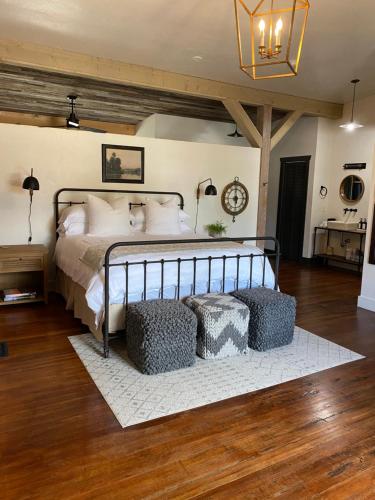 a bedroom with a large bed with two ottomans at Lander Millhouse in Lander