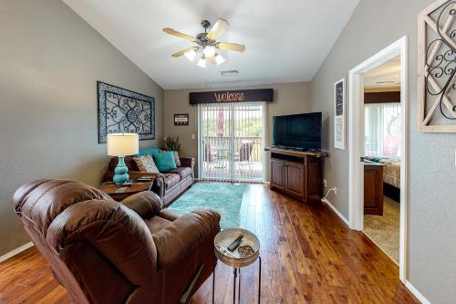 a living room with a couch and a tv at Woodpecker Watchtower in Branson